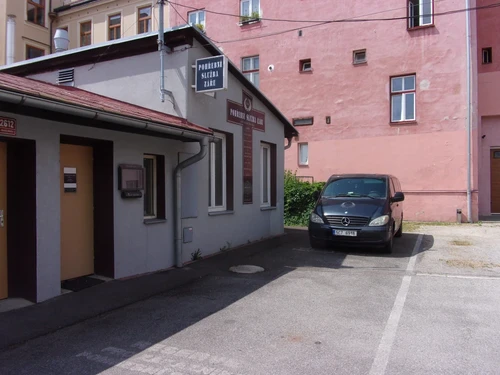 Provozovna Pohřební služby Záře s vývěsním štítem na fasádě a tmavým pohřebním vozem Mercedes-Benz Vito zaparkovaným ve dvoře.